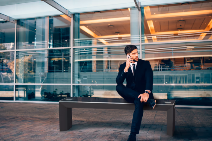 Man sitting on SmartBench solar charging station